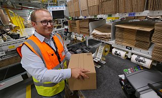 Standortleiter René Hille zeigt, wie ein Paket für den Kunden an einer Station verpackt wird. - Jost Wolf