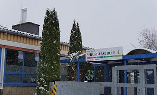 Auf dem Gebäude der Sekundarschule ist der Schornstein der Holzhackschnitzelheizung zu sehen, die Teile des Schulzentrums mit Wärme versorgt. Die Eisenkonstruktion rechts im Bild der der Zugang zum Bunker für die Holzreste. - Jost Wolf