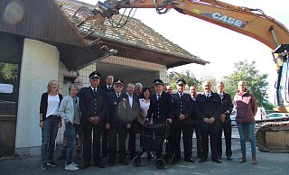 Vertreter der Löschgruppe Talle, der Verwaltung und Politik stellen sich für ein letztes Foto vor dem alten Feuerwehrgerätehaus auf, bevor es abgerissen wird. - Nadine Uphoff
