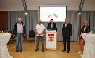 Thomas Katzer (links) und Dr. Andreas J. Wulf (2. von rechts) werden in zwei Wochen zur Stichwahl antreten. Martin Thiel (2. von links) und Carola Plaß erzielten Achtungserfolge. In der Mitte Wahlleiter Patrick Herrmann mit der Sitzverteilung im neuen Augustdorfer Rat. - Dieter Asbrock