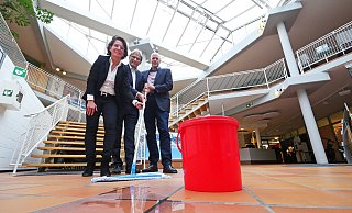 Es regnet durch: Eva Ellminger, Jörg Karlikowski und Stefan Freitag greifen hier symbolisch zum Aufnehmer der an regnerischen Tagen aber tatsächlich an mehreren Stellen im Gebäude zum Einsatz kommt. Und statt der großzügigen Eingangshalle im Stil der 80er Jahre brächten die Stadtwerke heute eher mehr Büro- und Besprechungsräume. - Jost Wolf