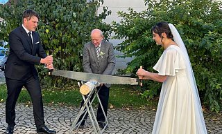 Traditionell zersägen Petrina und James Collier nach ihrer kirchlichen Hochzeit in Schwalenberg einen Baumstamm. - Bildrechte: Jams Collier Traditionell zersägen Petrina und James Collier nach ihrer kirchlichen Hochzeit in Schwalenberg einen Baumstamm. - Bildrechte: Jams Collier