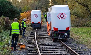 Die Monocabs sind auf der Teststrecke in Extertal ohne die orangefarbene Fangvorrichtung unterwegs und fahren aneinander vorbei. F&uuml;r alle F&auml;lle sind unter den Fahrzeugen Kufen angebracht, die aber in der Luft schweben, w&auml;hrend die Monocabs auf einer Schiene balancieren. - Peter Wehowsky