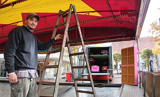 Maximilian Steuer baut den Autoscouter auf, der mitten auf dem Marktplatz steht. Drumherum gruppieren sich Marktstände. - Cordula Gröne