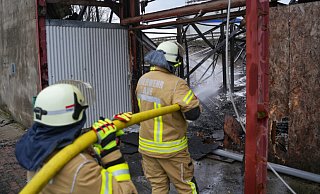 Am Tag nach dem nächtlichen Brand ist die Feuerwehr wieder für Nachlöscharbeiten an der Halle vor Ort. - Freitag TV/Leon Stock Am Tag nach dem nächtlichen Brand ist die Feuerwehr wieder für Nachlöscharbeiten an der Halle vor Ort. - Freitag TV/Leon Stock