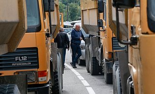 Zwei serbische Männer stehen neben einer Straße, die zum Grenzübergang Jarinje im Norden des Kosovo führt. - Visar Kryeziu/AP/dpa Zwei serbische Männer stehen neben einer Straße, die zum Grenzübergang Jarinje im Norden des Kosovo führt. - Visar Kryeziu/AP/dpa