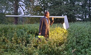 Künstler Jan Philip Scheibe stapft mit seiner Laterne durch ein Brennnessel-Feld. - Nadine Uphoff