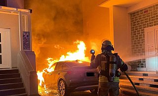 Das brennende Elektroauto stand in einer Einfahrt zwischen zwei Gebäuden, die durch das Feuer ebenfalls in Mitleidenschaft gezogen wurden. - Freiwillige Feuerwehr Lage