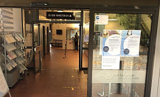 Der einzige öffentlich zugängliche Eingang ins Rathaus an der Rudolph-Brandes-Allee: Die Pfeile auf dem Boden weisen direkt zu dem kleinen Empfangstisch mit Spuckschutz im Hintergrund, an dem ein Mitarbeiter einer privaten Sicherheitsfirma jeden Besucher begrüßt und nach seinem Termin fragt. - Thomas Reineke