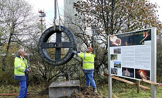Mitarbeiter bugsieren das 250 Kilogramm schwere Eichenrad an seinen neuen Standort am Köterberg. - Achim Krause Mitarbeiter bugsieren das 250 Kilogramm schwere Eichenrad an seinen neuen Standort am Köterberg. - Achim Krause
