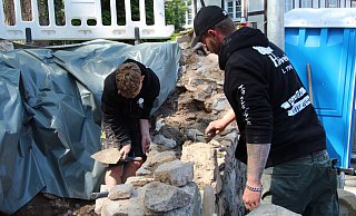 Jannes Klemme (links) und Kevin Kickert bauen die Bruchsteinmauer an der Herforder Straße wieder auf. - Nadine Uphoff Jannes Klemme (links) und Kevin Kickert bauen die Bruchsteinmauer an der Herforder Straße wieder auf. - Nadine Uphoff