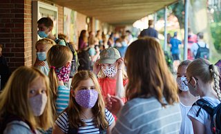 Schülerinnen einer sechsten Klasse stehen vor Beginn des Unterrichts am ersten Schultag nach den Sommerferien an der Max-Planck-Schule in Kiel zusammen. Hier ist die Schule bereits am Dienstag gestartet. - Gregor Fischer/dpa