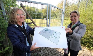 Ute Seidemann (links) und Ewa Hermann vom Bauamt der Gemeinde Kalletal stehen vor dem zurzeit verschlossenen ehemaligen Basketballplatz und zeigen den Plan f&uuml;r die Parkour-Anlage. - Jens Rademacher