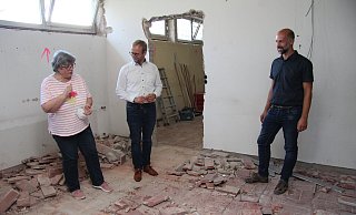 Schulleiterin Gabriele Schmuck (von links), Bürgermeister Borris Ortmeier und Fachbereichsleiter Chris Hütte-Getboga schauen sich die Abbrucharbeiten am Gymnasium an. - Nadine Uphoff