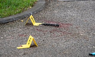 Blut und Markierungen der Polizei sind am Tatort zu sehen. - Foto: Matthias Balk/dpa