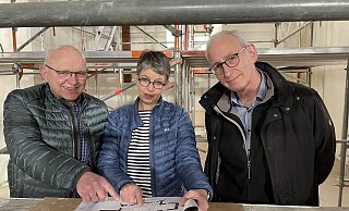 Viele Gerüste im Chorraum: Innenarchitektin Antje Hellmig, Pfarrer Peter Thimm (rechts) und Bauausschussvorsitzender Heinz-Gerhard Nölting machen sich ein persönliches Bild vom Fortgang der Bauarbeiten. - Kirchengemeinde Bösingfeld