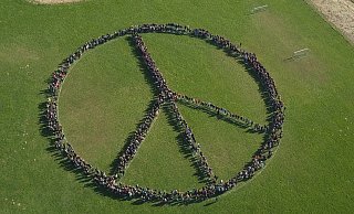 1300 Schülerinnen und Schüler der Karla-Raveh-Gesamtschule haben sich zu einem großen Peace-Zeichen aufgestellt und mit einer Drohne aufgenommen. - Karla-Raveh-Gesamtschule