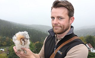 Falkner Benjamin Aschmann mit einem kleinen Patienten. Die Schleiereule ist ungefähr drei Wochen alt und im Teutoburger Wald aus dem Nest gefallen. - Archivfoto: Janet König