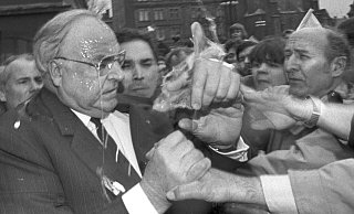 Nachdem er getroffen wurde, versucht Kohl, den Angreifer in der Menge ausfindig zu machen. (Archivbild) - picture alliance / Peter Kneffel/dpa Nachdem er getroffen wurde, versucht Kohl, den Angreifer in der Menge ausfindig zu machen. (Archivbild) - picture alliance / Peter Kneffel/dpa