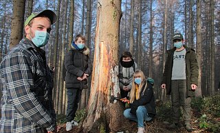 Eric Wunsch (von links) zeigt den Schüler, Elias, Tamay, Michelle und Marlon, wie es unter der Rinde der toten Fichten im Stadtwald aussieht. - Carolin Brokmann-Förster Eric Wunsch (von links) zeigt den Schüler, Elias, Tamay, Michelle und Marlon, wie es unter der Rinde der toten Fichten im Stadtwald aussieht. - Carolin Brokmann-Förster