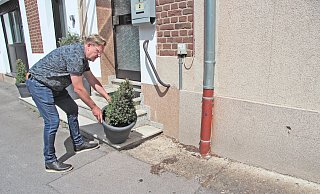 Takis Poursanidis stellt seinen Blumenkübel wieder richtig hin, nachdem dieser offenbar umgestoßen wurde. Davon zeugt die Erde auf dem Boden. Das Loch rechts passt von der Höhe, Größe und Form zu einer Anhängerkupplung. - Nadine Uphoff