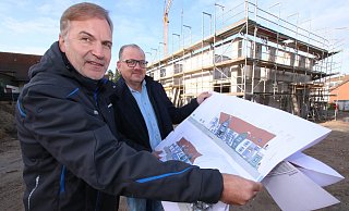 Andreas Kelle, Gesellschafter der Kelle Wohnwert GmbH, und Milko Kemmler (von links), Inhaber der ambulanten Kranken- und Altenpflege "Pflege vor Ort", stehen auf der Baustelle in Heidenoldendorf und sehen sich Ansichten des Hauses an, in dem altengerechte Wohnungen und eine Wohngruppe für Pflegebedürftige entstehen werden. - Patrick Bockwinkel