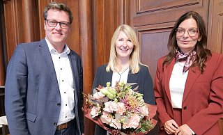 Der f&uuml;r die Feuerwehr zust&auml;ndige Beigeordnete Jochen Strieckmann (links) und Herfords B&uuml;rgermeisterin Anke Theisen (rechts) gratulieren Marilena Nolting. - Stadt Herford