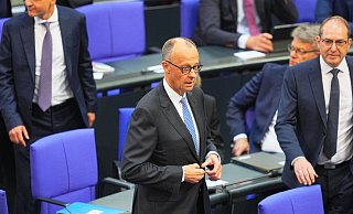 Der designierte Bundeskanzler Friedrich Merz (CDU, M) reagiert im Bundestag bei der Kanzlerwahl. Merz ist bei der Kanzlerwahl im Bundestag im ersten Wahlgang durchgefallen. - Michael Kappeler/dpa