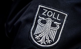 Das Zoll Abzeichen auf der Uniform eines Beamten. - Sina Schuldt/dpa/Symbolbild Das Zoll Abzeichen auf der Uniform eines Beamten. - Sina Schuldt/dpa/Symbolbild