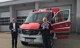 Bürgermeister Markus Baier und Feuerwehrchef Klaus Wegener zeigen die Informationen der Unfallkasse NRW für Ersthelfer, die bei der Freiwilligen Feuerwehr Lemgo im Einsatz sind.  - Alte Hansestadt Lemgo