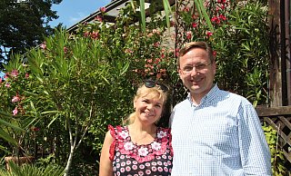Andreas Wulf steht mit seiner Frau Lolita im Garten vor der Terrasse, an der der Oleander blüht. Die Zucht der Pflanzen sowie die Gartenarbeit gehören zu seinen Hobbys. - Nadine Uphoff