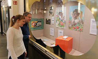 Pia Gillner und Arnold Beuke schauen sich eines der umgestalteten Schaufenster in der Wandelhalle an. - Alexandra Schaller