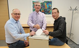 Zeigen, wie das Wählen geht: (von links) Fachbereichsleiter Frank Rayczik, Wahlleiter Technischer Beigeordneter Thorsten Paulussen und Peter Bergmann vom Fachteam Orga/Wahlen mit einer der Urnen, die am 26. Mai zum Einsatz kommen. - Wolfgang Becker