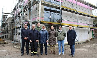 Michael Little (stv. Leiter Feuerwehr Kalletal, von links), Andreas Wagner (Löschgruppenführer Talle), Simon Prüßner (SPD-Ratsmitglied), Brigitte Lähnemann (UKB-Ratsmitglied), Architektin Wera Binder, Nikolai Stoll (Fachbereich Planen und Bauen) und Bürgermeister Mario Hecker vor dem Neubau des Feuerwehrgerätehauses in Talle. - Lorraine Brinkmann