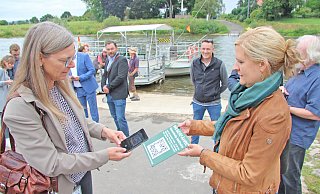 Die Weserfähre wird viel genutzt. Sensoren übermitteln neuerdings, ob die Fähre einsatzbereit ist. Radler und Wanderer können die Daten im Internet über www.kalletal.de/weserfaehre abrufen. Das geht auch per QR-Code, wie Michaela Lehnert vom Kommunalen Rechenzentrum (links) und Corinna Will von der Gemeinde Kalletal demonstrieren. Die Schilder werden an mehreren Stellen aufgestellt. - Jens Rademacher Die Weserfähre wird viel genutzt. Sensoren übermitteln neuerdings, ob die Fähre einsatzbereit ist. Radler und Wanderer können die Daten im Internet über www.kalletal.de/weserfaehre abrufen. Das geht auch per QR-Code, wie Michaela Lehnert vom Kommunalen Rechenzentrum (links) und Corinna Will von der Gemeinde Kalletal demonstrieren. Die Schilder werden an mehreren Stellen aufgestellt. - Jens Rademacher