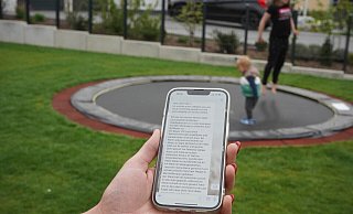 Laura Freitag zeigt auf ihrem Handy die WhatsApp-Nachricht. Der Sohn (2) und die Tochter (8) spielen im Hintergrund. - Tim Freitag