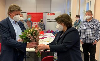 Kreisvorsitzende Ellen Stock gratuliert Jürgen Berghahn mit Blumen. - SPD