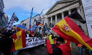 Polizisten laufen während des Protestmarsches am spanischen Parlament in Madrid vorbei. - Foto: Paul White/AP/dpa Polizisten laufen während des Protestmarsches am spanischen Parlament in Madrid vorbei. - Foto: Paul White/AP/dpa