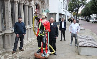 Der Feuerwehr-Hermann weist auf die Sonderausstellung hin. Mit im Bild: (von links) Jan Pieniak von der Hochschule, Klaus Wegener (Leiter der Feuerwehr), Markus Baier (designierter Bürgermeister) und Museumsleiter Fabian Schröder. - Kirsten Fuhrmann