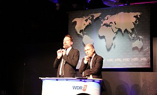 Adrian Engels und Markus Riedinger alias „Onkel Fisch“ geben als Nachrichtensprecher der besonderen Art Vollgas im Ziegeleimuseum. - Sandra Castrup Adrian Engels und Markus Riedinger alias „Onkel Fisch“ geben als Nachrichtensprecher der besonderen Art Vollgas im Ziegeleimuseum. - Sandra Castrup