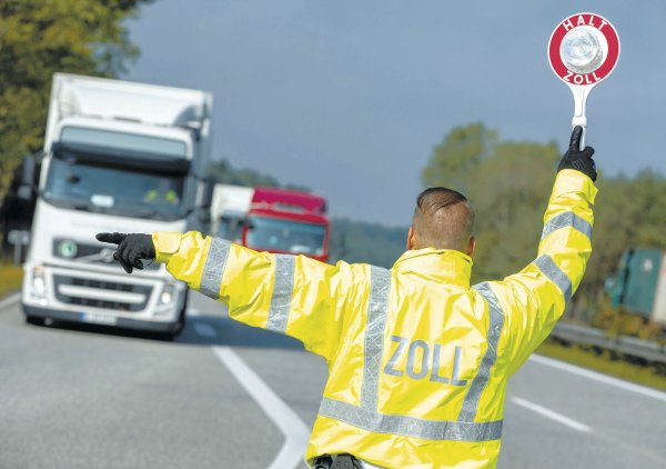 Kontrolle: Ein Zollbeamter winkt einen Lastwagen auf einen Autobahnparkplatz - © dpa