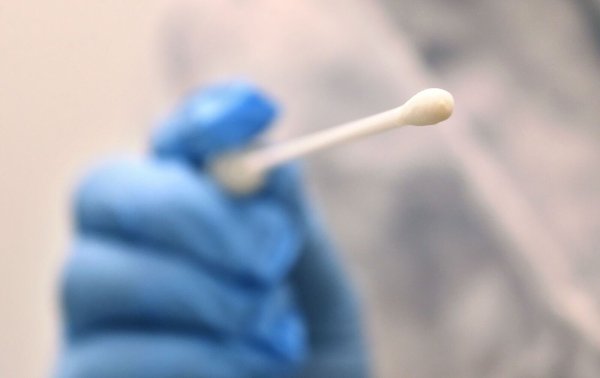 Ein Arzt hält einen Tupfer, mit dem ein Abstrich für einen Coronatest gemacht wird. - © Karl-Josef Hildenbrand/dpa/Symbolbild