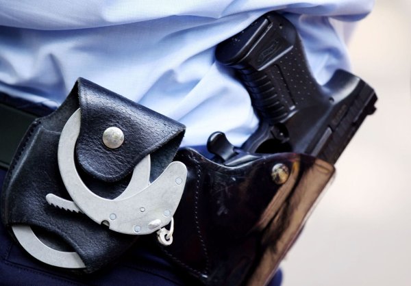 Ein Polizist mit Handschellen und Pistole am Gürtel. - © Oliver Berg/dpa/Archivbild