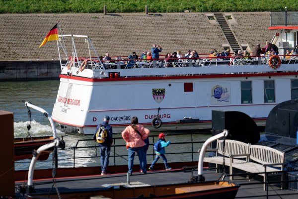 Spaziergänger genießen in Duisburg Ruhrort Sonnenstrahlen am Ufer des Vinckekanals. - © Henning Kaiser/dpa