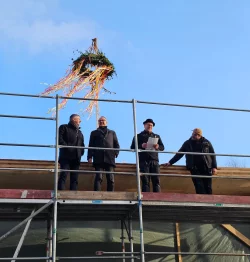 Oben strahlt die Sonne, unten die Gesichter beim Richtfest desKindergartens Dewitzstraße: (von links) Bernd Meier, technischer Abteilungsleiter der Gebäudewirtschaft Lemgo, Bürgermeister Markus Baier, Veit Nahrwold und Joseph Haffert, Gesellschafter von Vagabund Holzbau. - © Stadt Lemgo