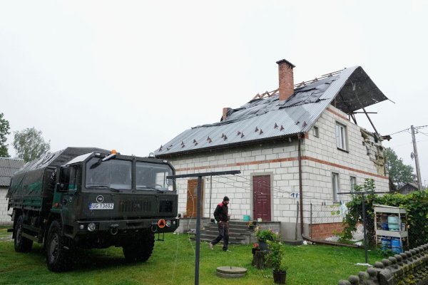 Ein Mann geht an einem beschädigten Haus vorbei, nachdem russische Drohnen den polnischen Luftraum verletzt haben. (Archivbild) - © Czarek Sokolowski/AP/dpa