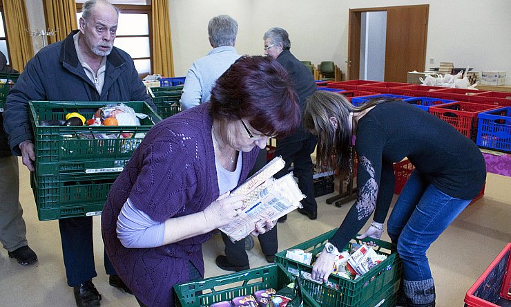 Es bedarf vieler zupackender Helfer, die die zahlreichen Kisten voller Lebensmittel bei der Anlieferung ins Gemeindehaus schleppen. - © Privat