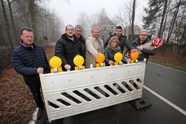 Schlänger fühlen sich durch die Sperre ausgegrenzt. Bodo Kibgies, Andre Pestrup, Heinrich Kuhlmeier, Henning Schwarze, Edeltraud Kuhlmeier, Maximilian Scholz und Dieter Vollmer haben sich fürs Foto hiter der Sperrbarke am Kreuzkrug versammelt. - © Bernhard Preuss