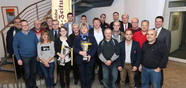 Um diese zwei Pokale geht es: LZ-Marketing-Leiterin Barbara Lucas (links, hält den Männerpott) und Elke Albert von Titelverteidiger FC Donop/Voßheide mit Sponsoren, Ausrichtern und Offiziellen der FuL-Kreise. Foto: Paul Cohen - © Paul Cohen