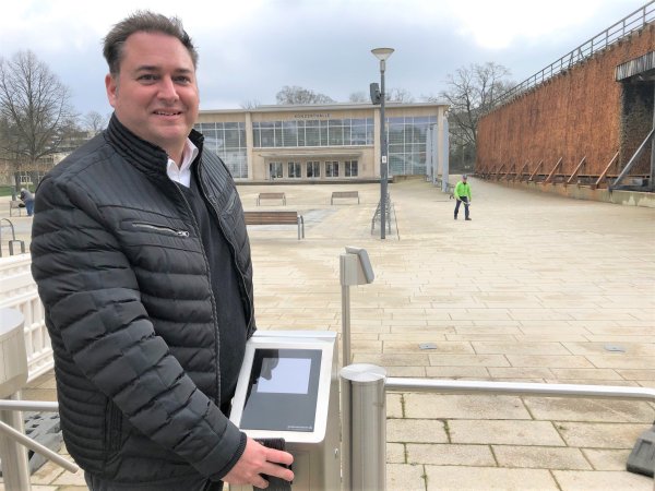 Kurdirektor Stefan Krieger hält sein Handy an das neue automatische Drehkreuz am Kurpark-Haupteingang. Auf dem Handy sind die Daten seiner Salzuflen-Card gespeichert. Ein QR-Code auf dem Display des Handys entsperrt das Kreuz. - © Thomas Reineke
